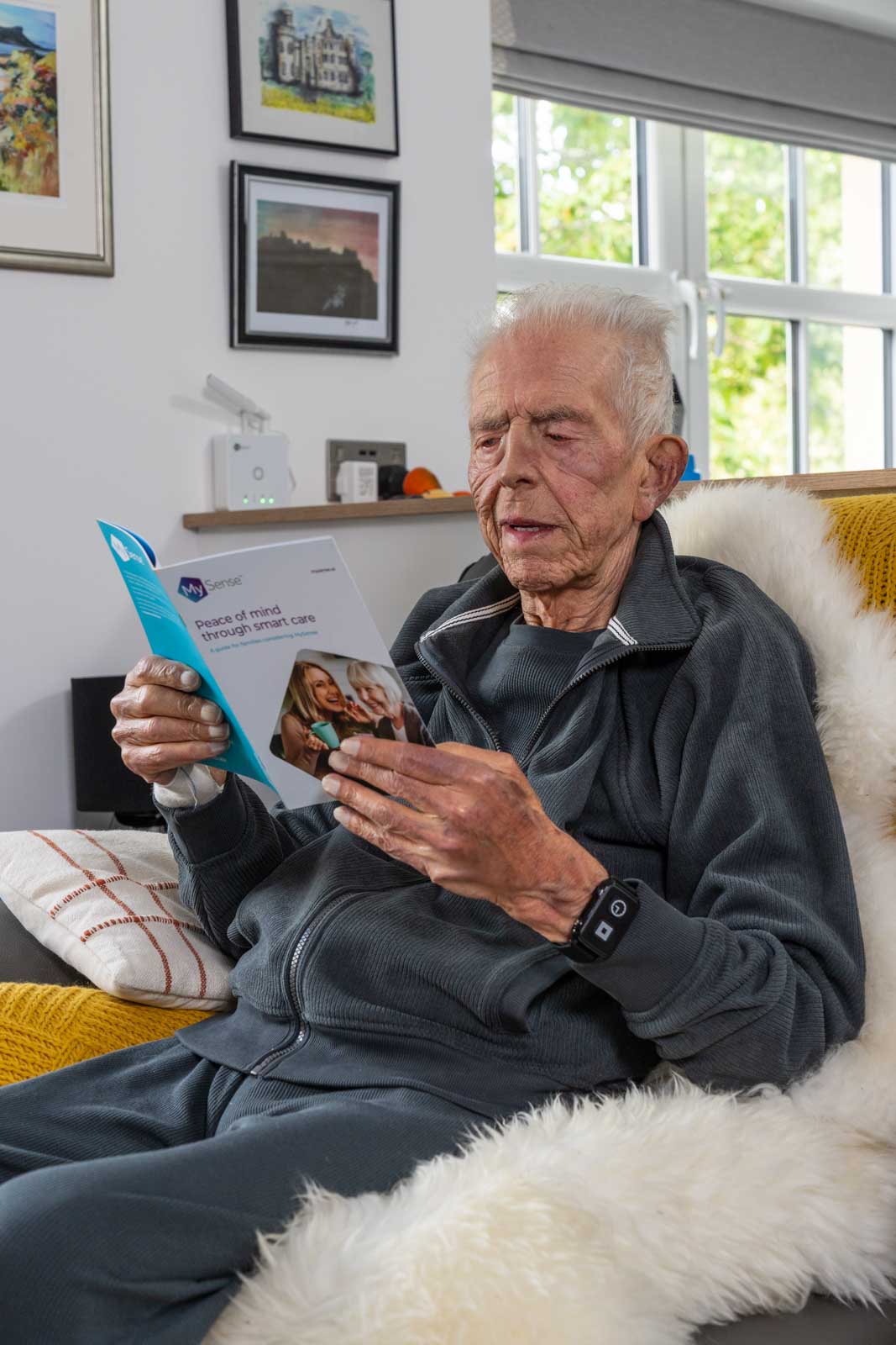 A family member wearing the MySense Roam watch and the wall hub connected reading the Family Decision Making Guide